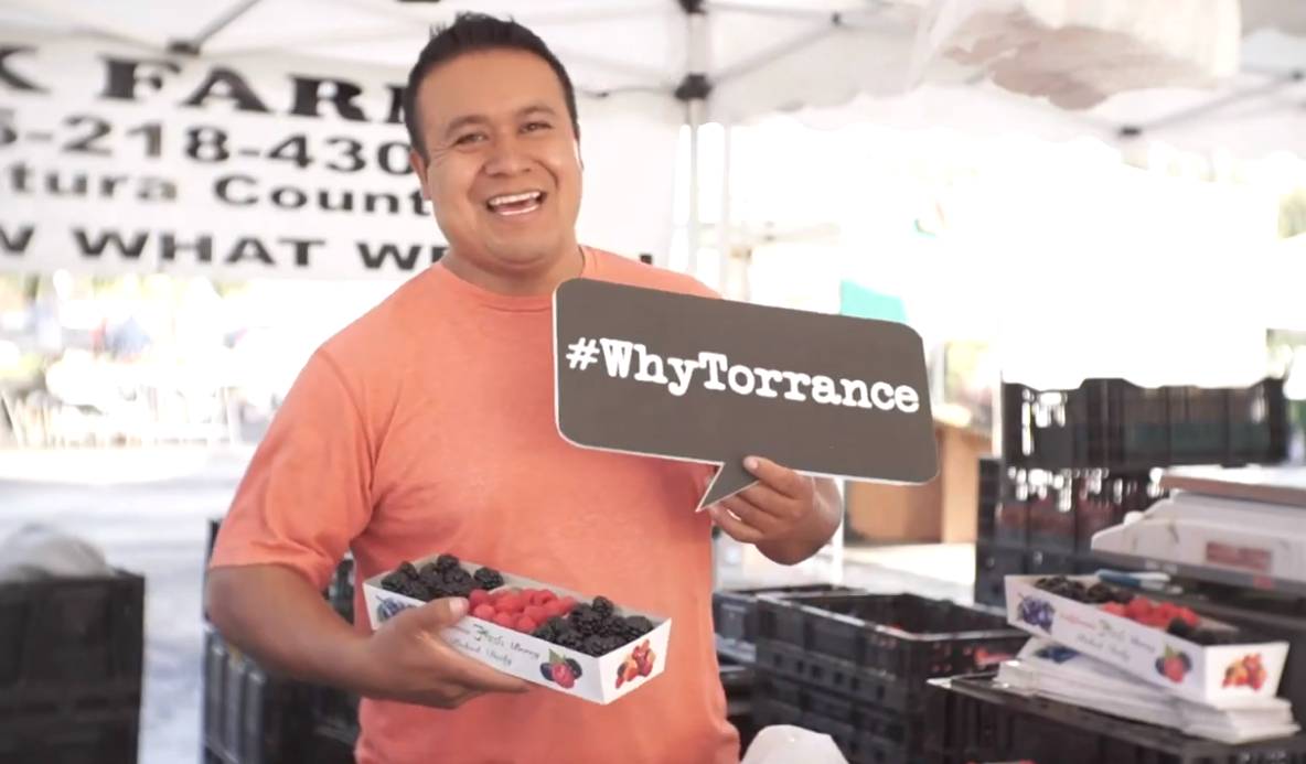 Man holding strawberries and sign