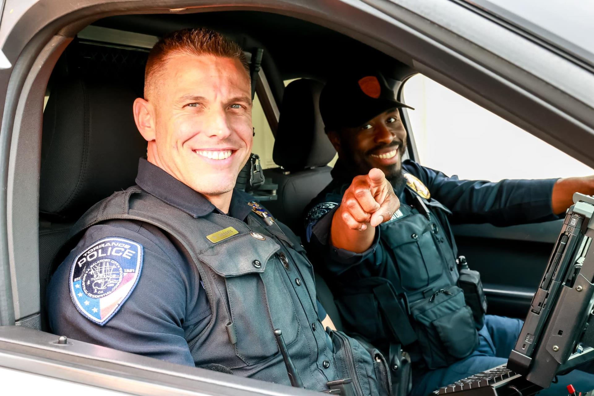 Two Torrance Police officer sitting in the car smiling